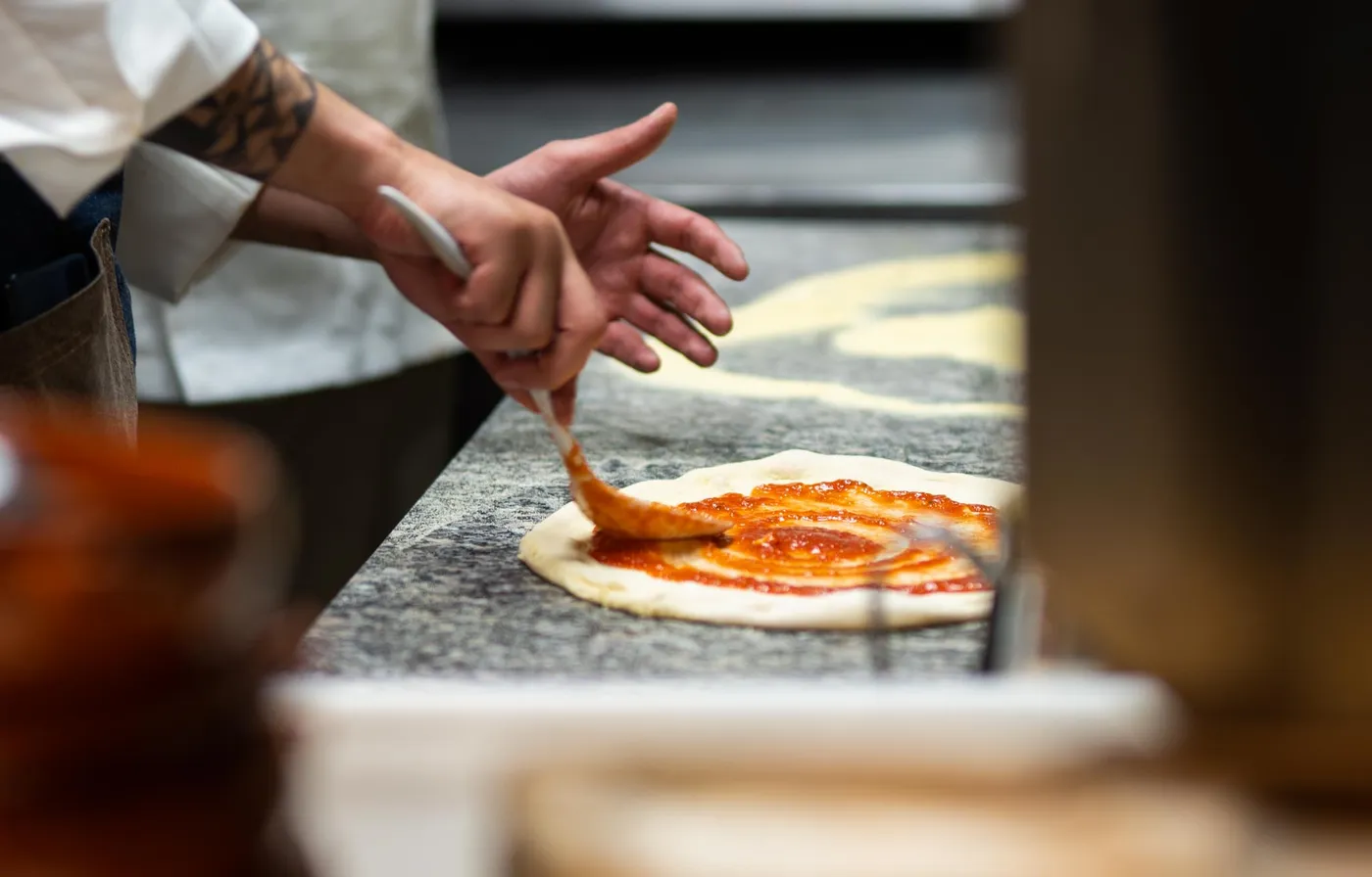 Pizzadeig strekkes ut for hånd
