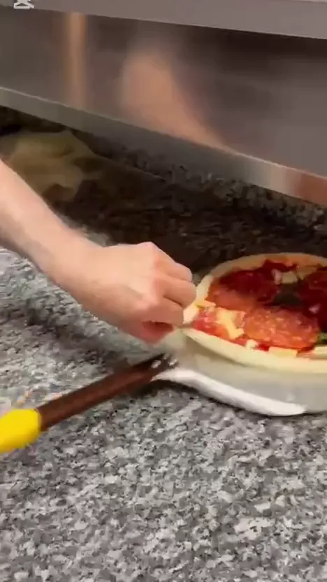 Pizzaen skyves inn i steinovnen