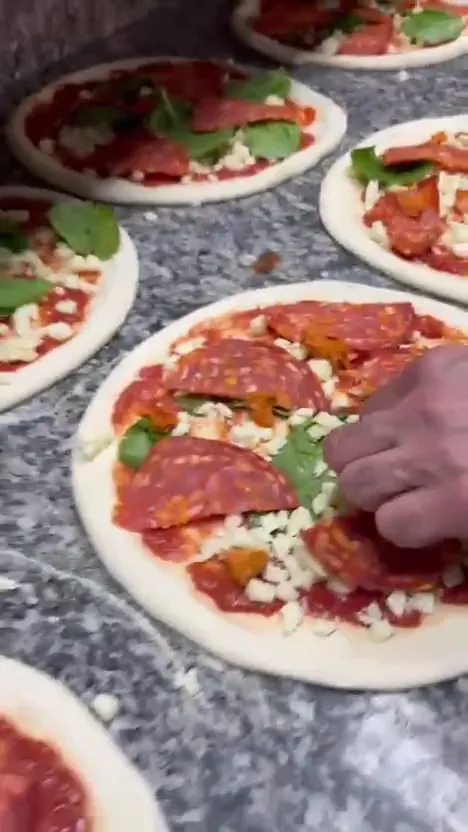 Pizzaer gjøres klare på benken
