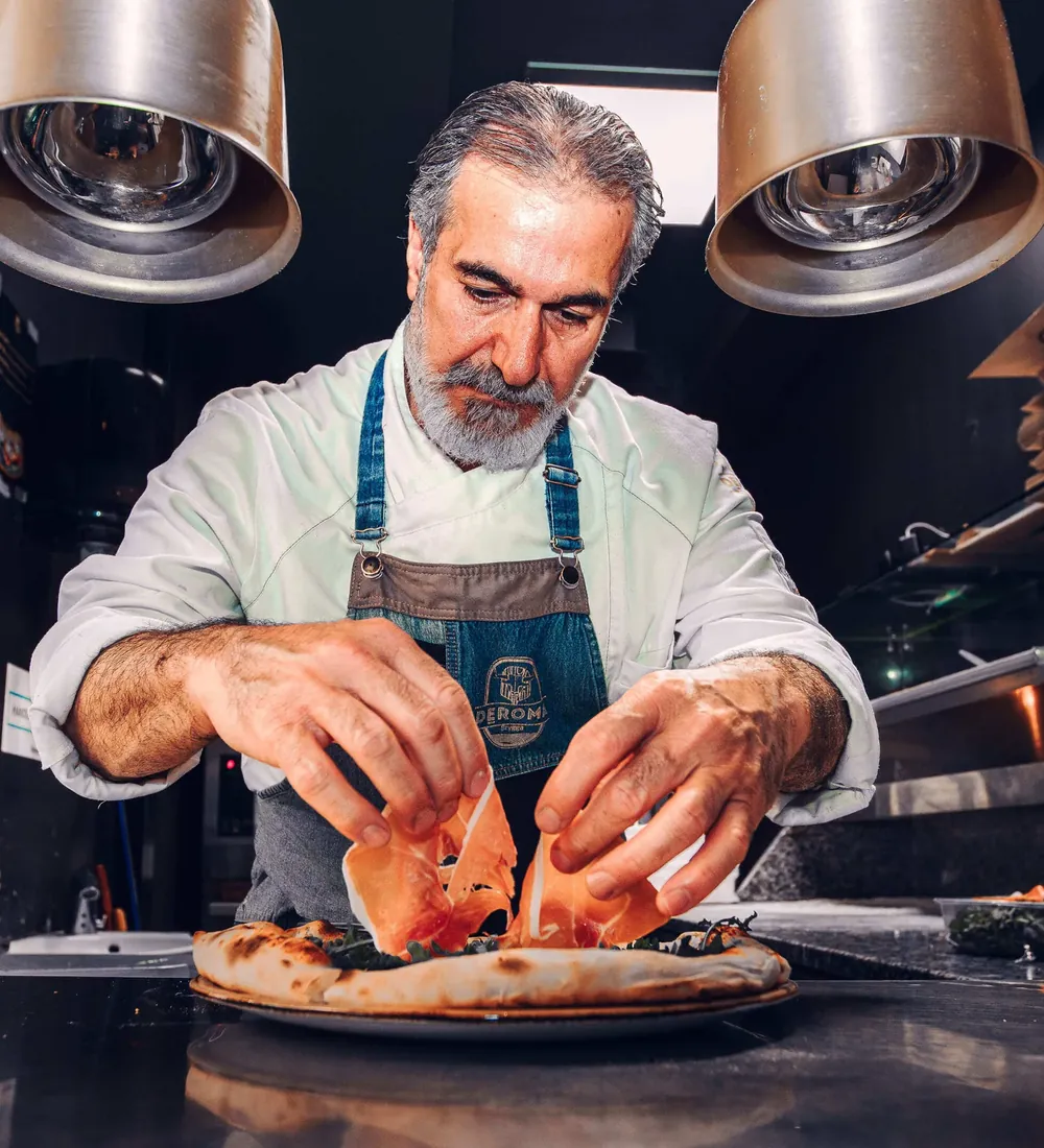 Shawan legger parmaskinke på en pizza